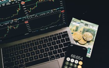 Laptop screen displaying market graphs and financial charts.